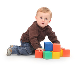 Little kid playing with toy blocks.